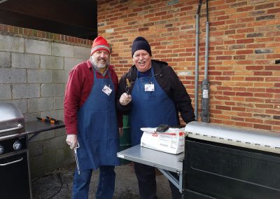 men cooking on an outdoor grill